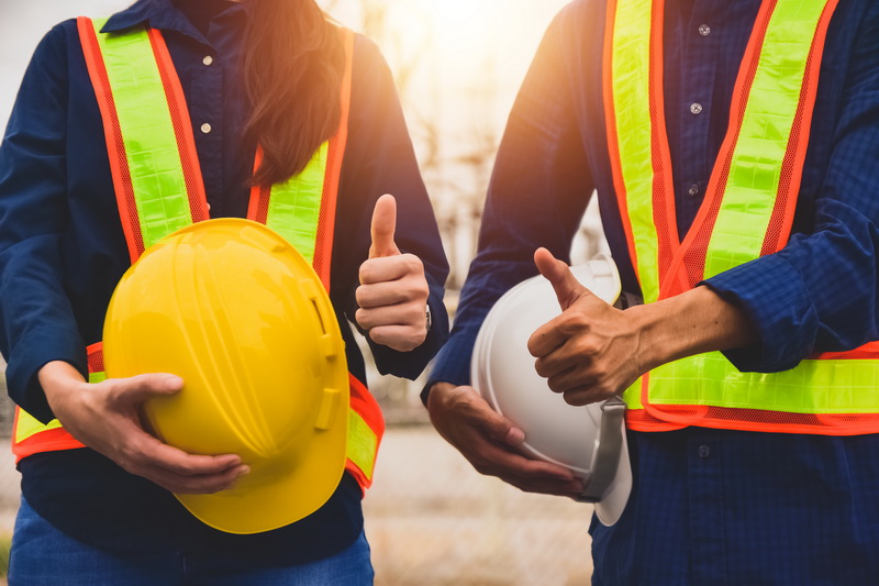 Team  Engineer holding safety helmet on factory background