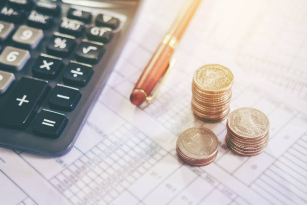 Calculator and coin on the business paper. Report chart
